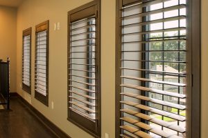 Wooden shutters in a yellow room with dark wood flooring