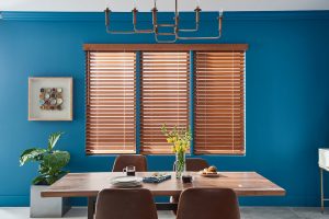 Wood blinds in blue dining room having table chairs in it