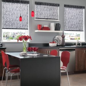 Swirl-patterned roller shades hanging over windows in a kitchen