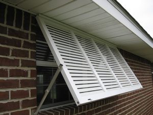 exterior shutter covering a window on the exterior of a brick home